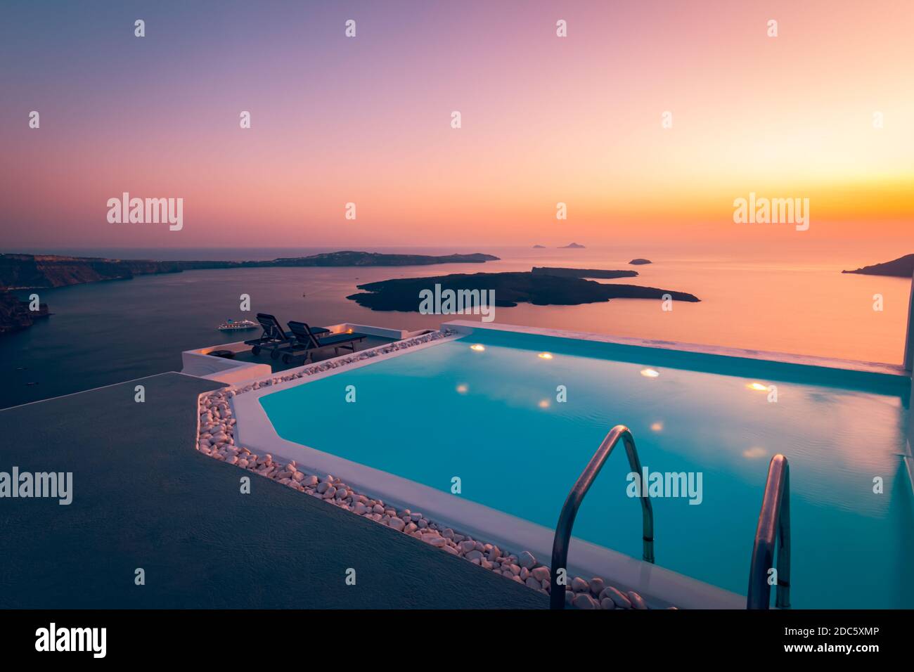 Luxurious summer vacation and holiday landscape, romantic scenery. Infinity pool on the rooftop at sunset in Santorini Island, Greece. Poolside sunset Stock Photo