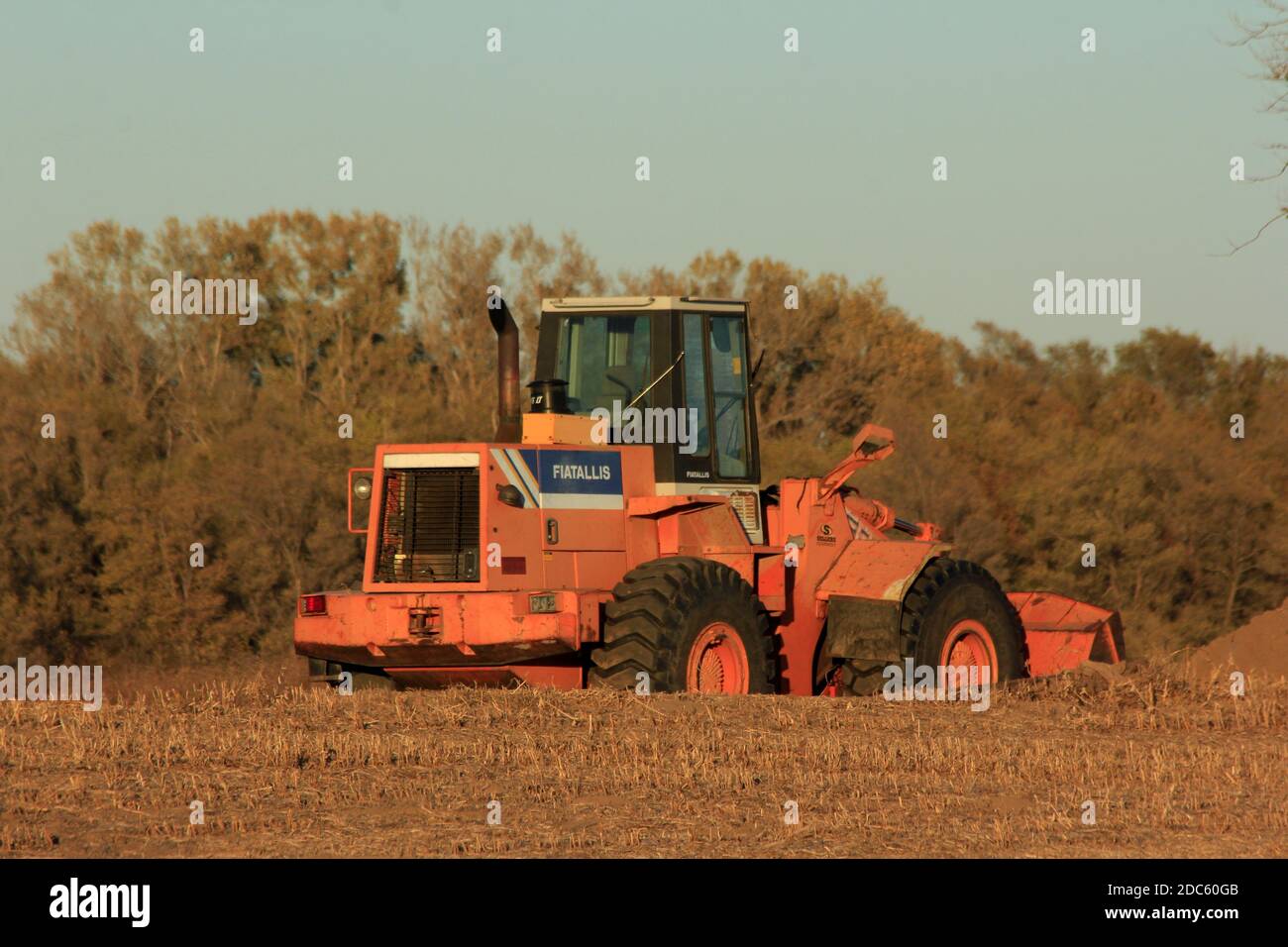 A Fiatallis Heavy Equipment Front end loader in a farm field  ready for work with blue sky and tree's out in the country in Kansas on a fall day. Stock Photo