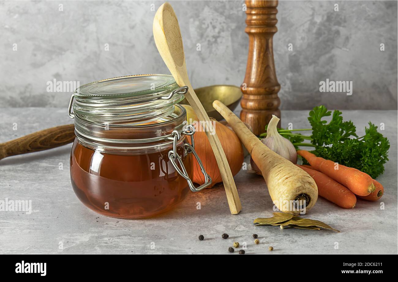 Homemade beef bone broth with ingredients. Contains minerals and healthy nutrients, including vitamins, amino acids, and essential fatty acids. Stock Photo