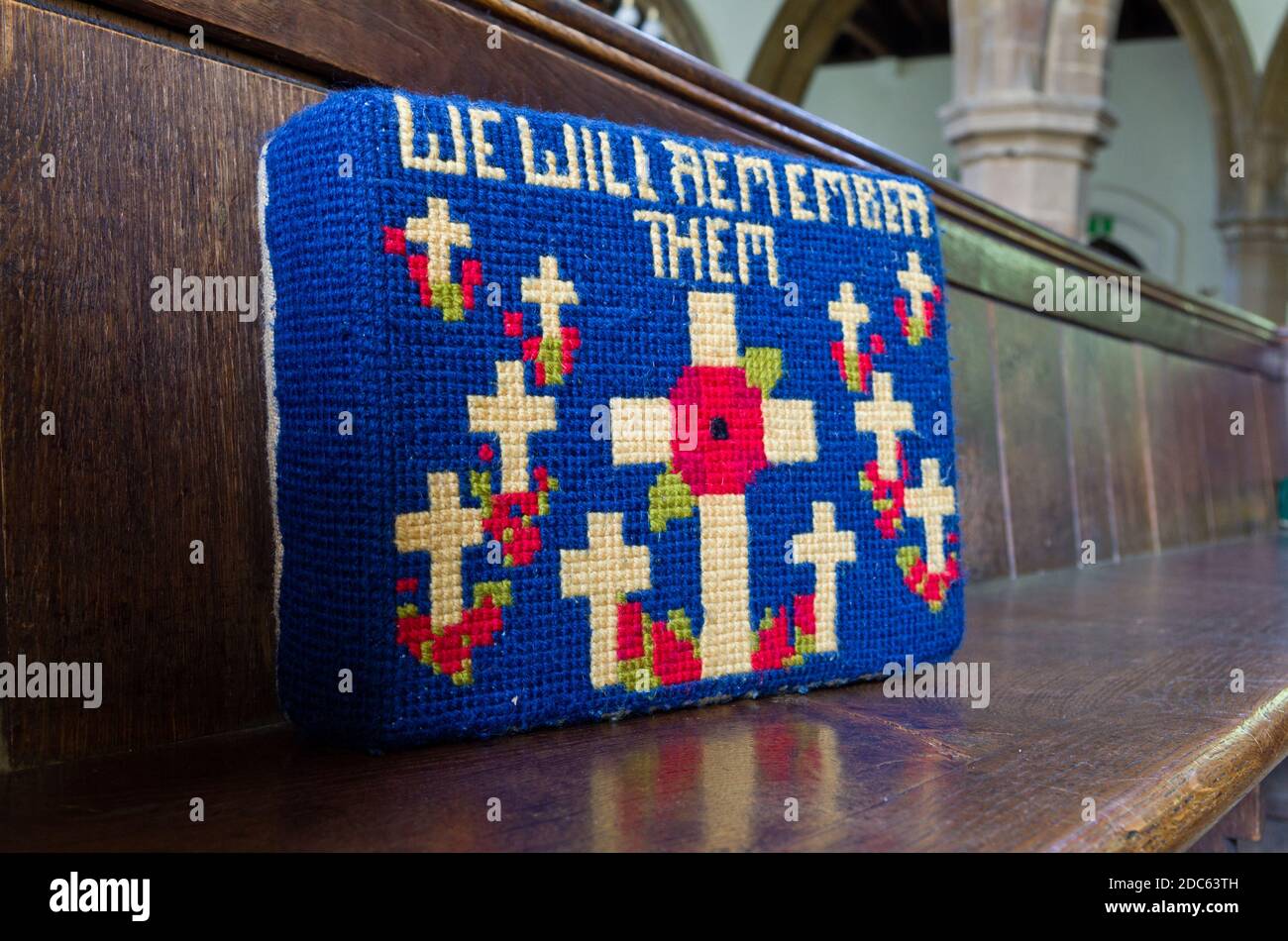 Embroidered kneeler, prayer cushion or hassock on a pew in a UK church