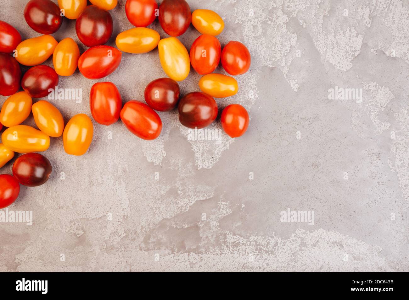 Cherry tomatoes on gray marble background. Copyspace. Stock Photo