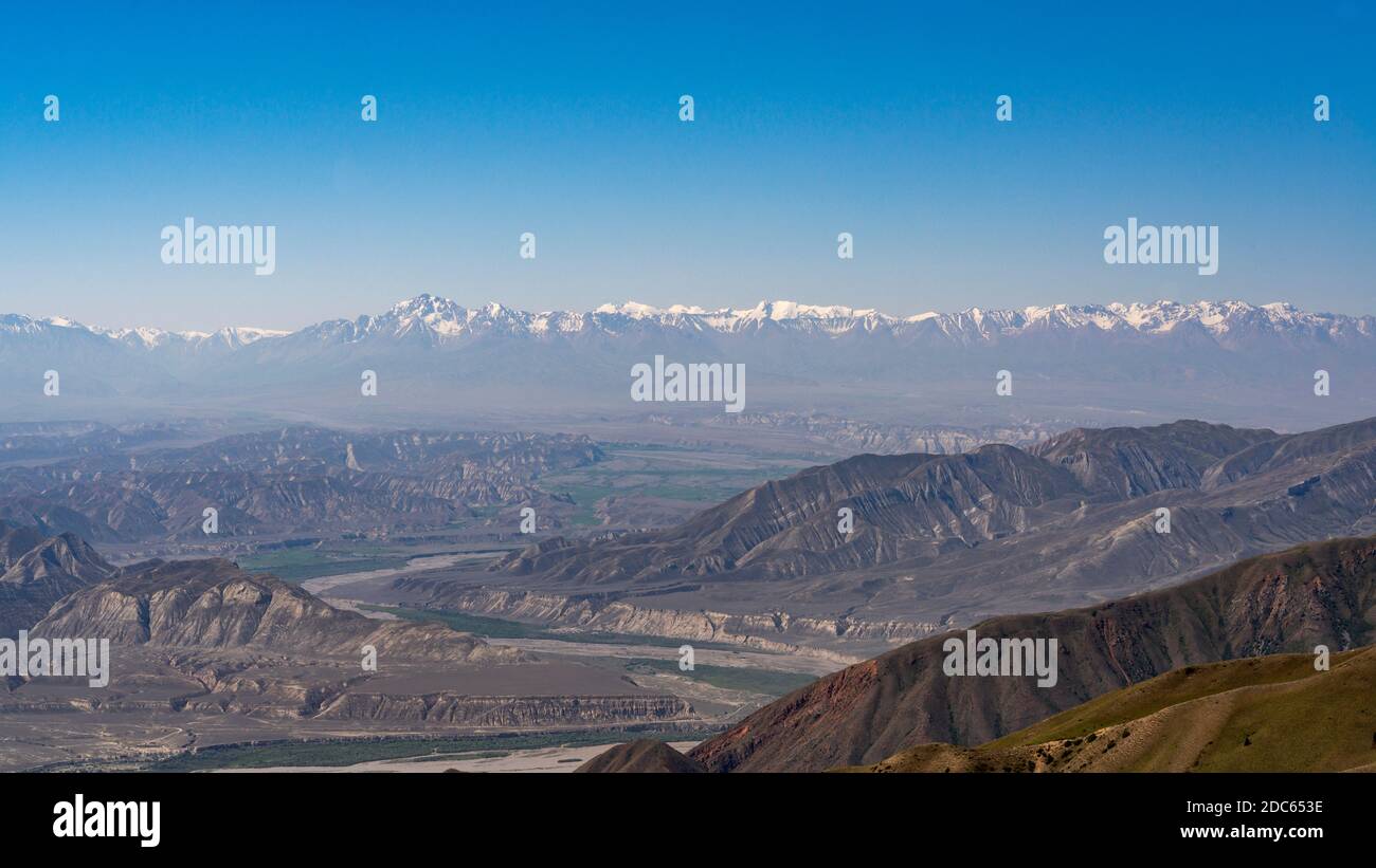 Panorama of the Toguz Toro Pass with valley Kyrgyzstan on a summers day with blue sky and mountains with snow. Stock Photo