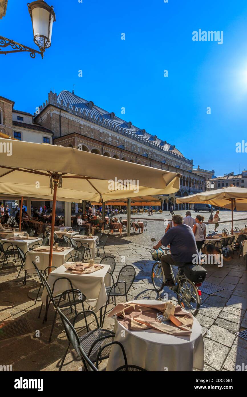 Cafe, cyclist and Ragione Palace from Piazza della Frutta, Padua, Veneto, Italy Stock Photo