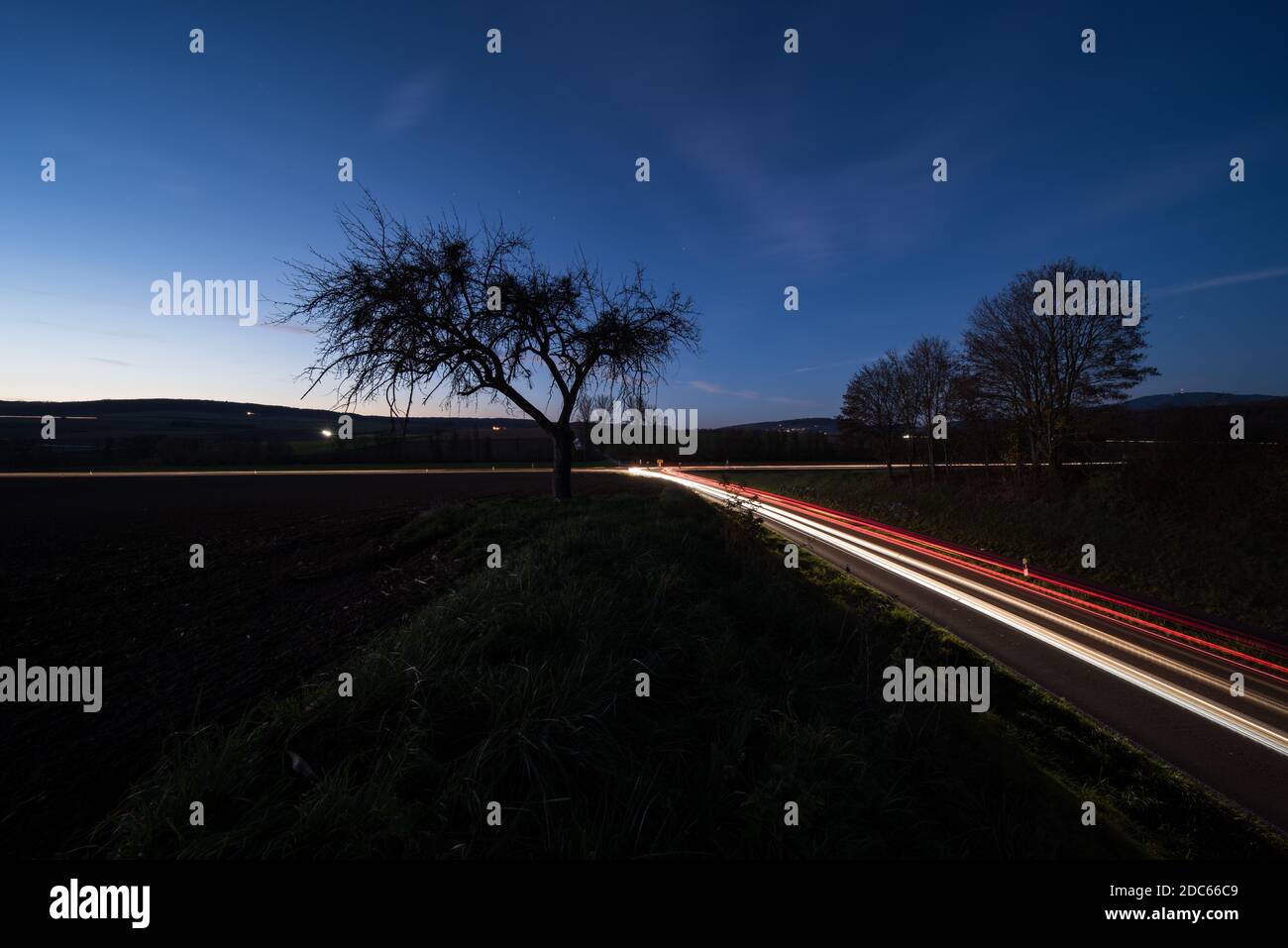 Light trails from cars at night on a country road in Germany Stock Photo