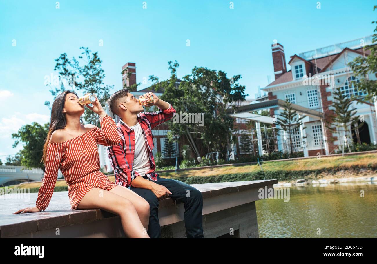 Beer Party - Young couple enjoying hot summer day at a rooftop party, drinking Ganzberg beer and having fun Stock Photo