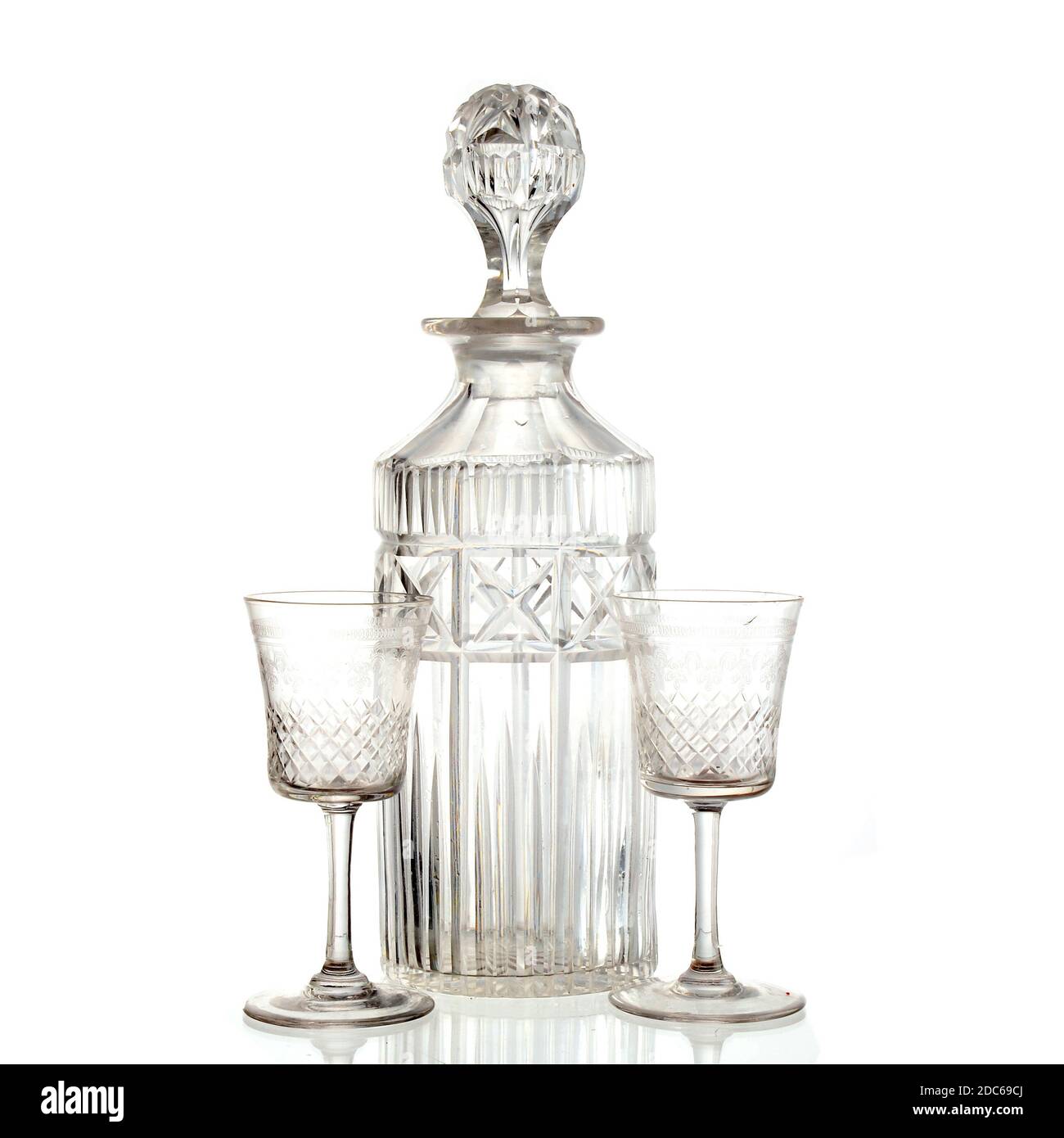 Vintage cut glass decanter and two crystal sherry glasses on white background. studio shot Stock Photo