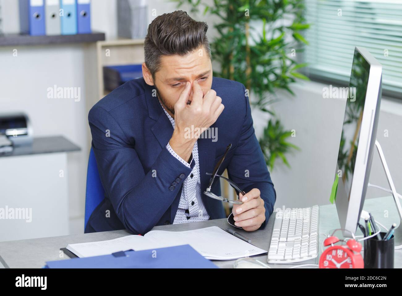 tired businessman with eyeglasses in office Stock Photo