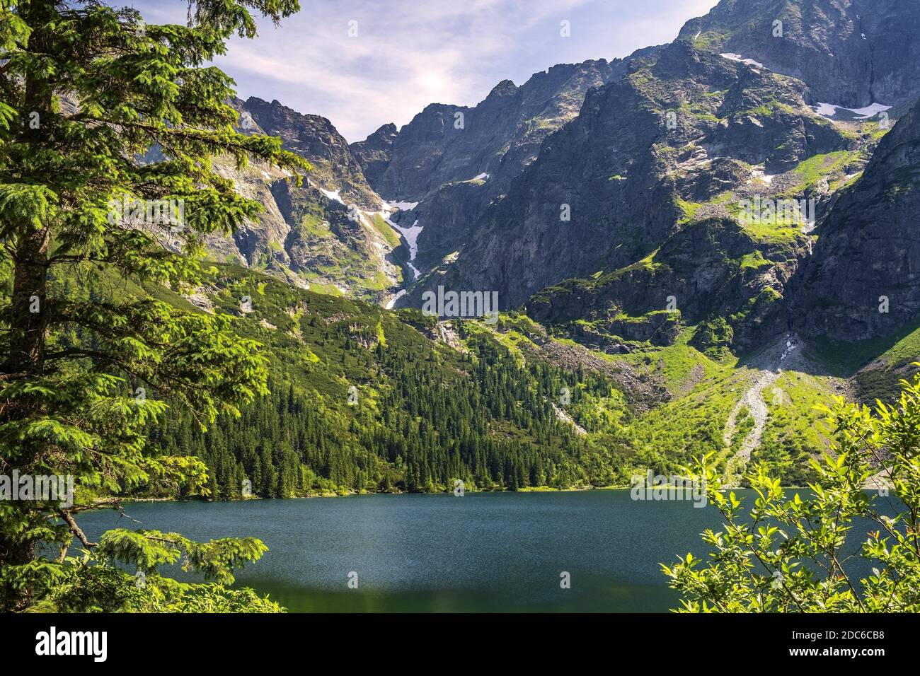 Panoramic view of the Morskie Oko mountain lake with High Tatra Mountains peaks - Zabia Turnia, Wolowy Grzbiet, Kazalnica and Czarny Staw pod Rysami, Stock Photo