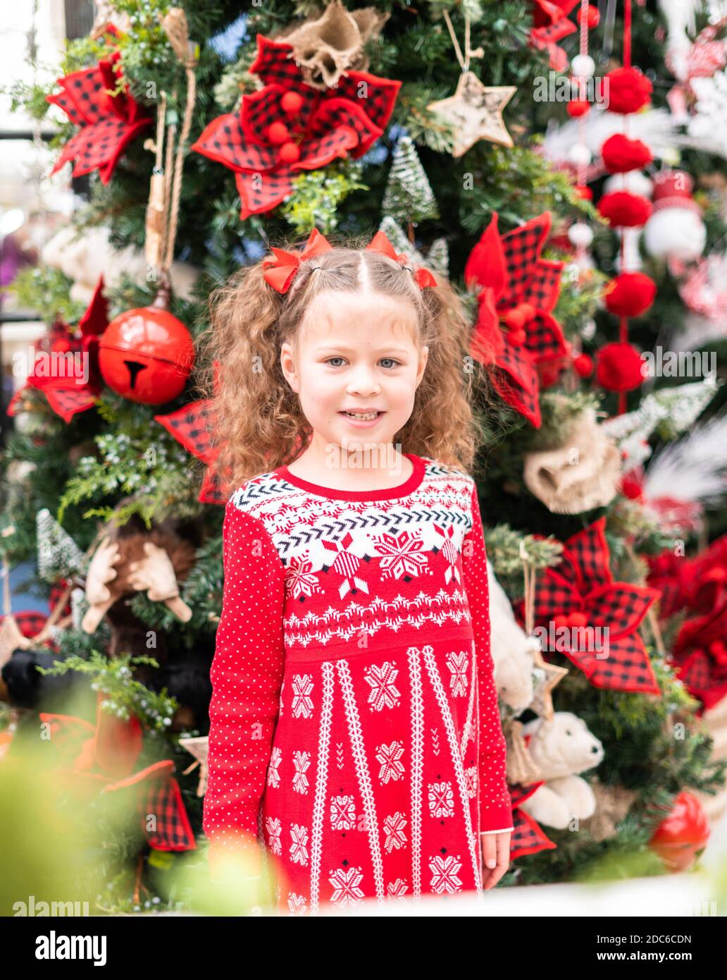 Little girl in red dress at the Christmas tree farm Stock Photo - Alamy