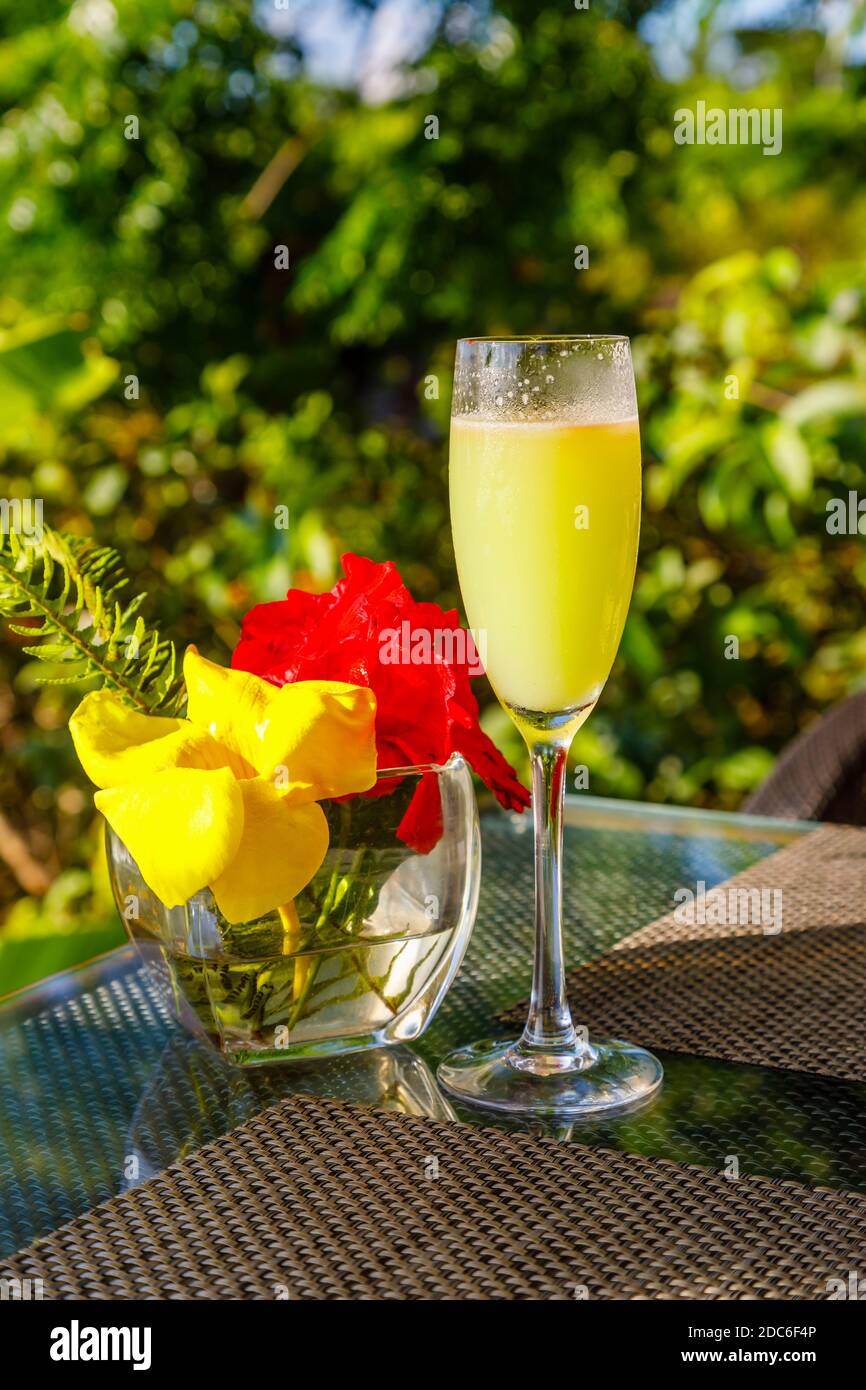 A tropical sparkling cocktail served in a champagne flute on a bar