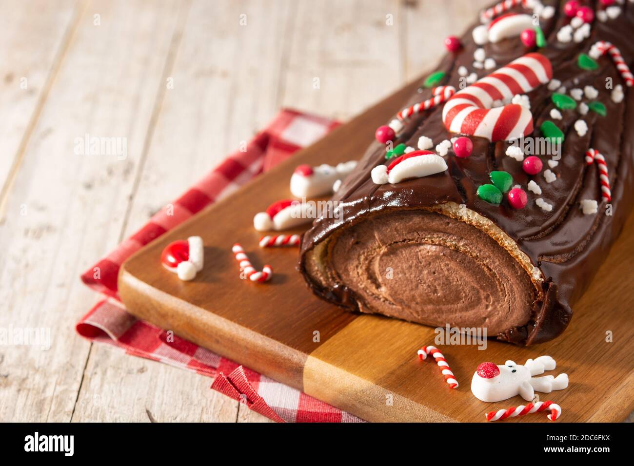 Chocolate yule log christmas cake on wooden table Stock Photo
