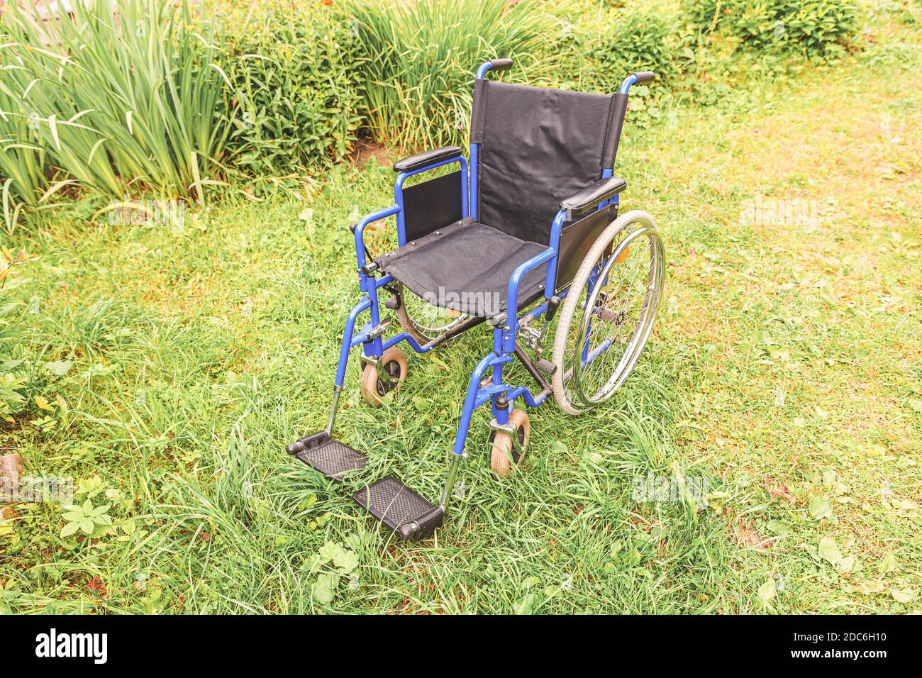 Empty wheelchair standing on grass in hospital park waiting for patient ...