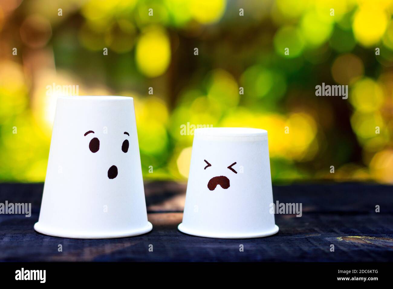 Two cups with painted faces as a symbol of a sad child and a worried ...