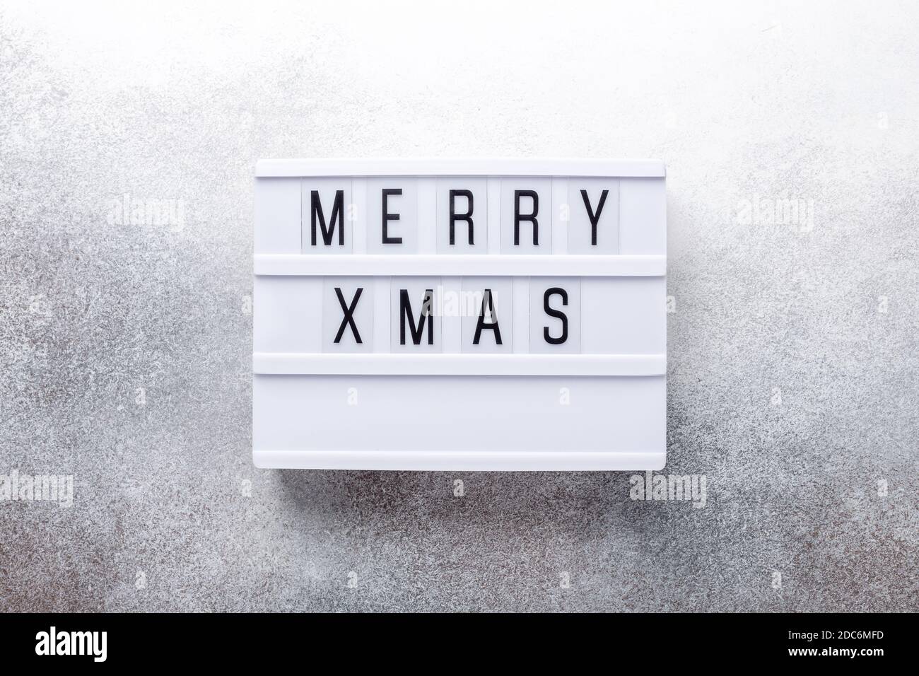 Lightbox with text MERRY XMAS on stone background - Image Stock Photo