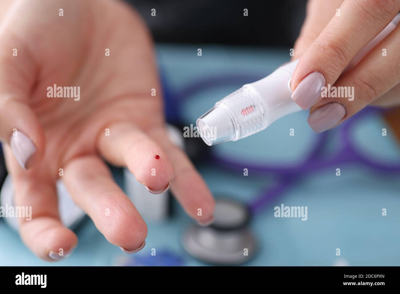 Blood sampling from a finger with lancet Stock Photo Alamy