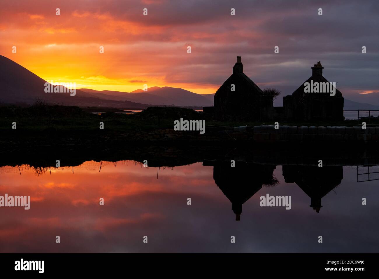 Reflection of Silhouette of Ruined Cottage and Red Sky in Canal Water in Tralee, County Kerry, Ireland Stock Photo