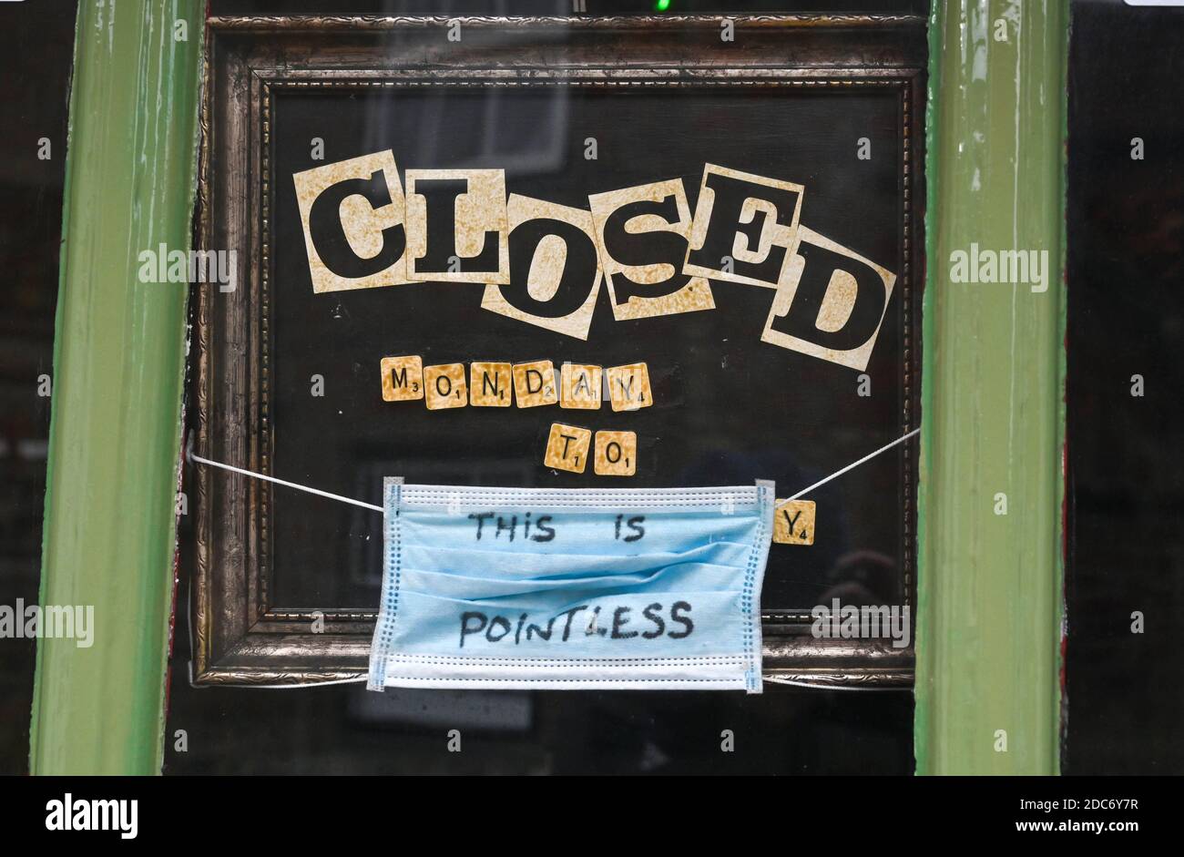 Alfriston Sussex - Face mask covering hanging in a shop window with the slogan This is Pointless written in ink on it during the coronavirus COVID-19 Stock Photo