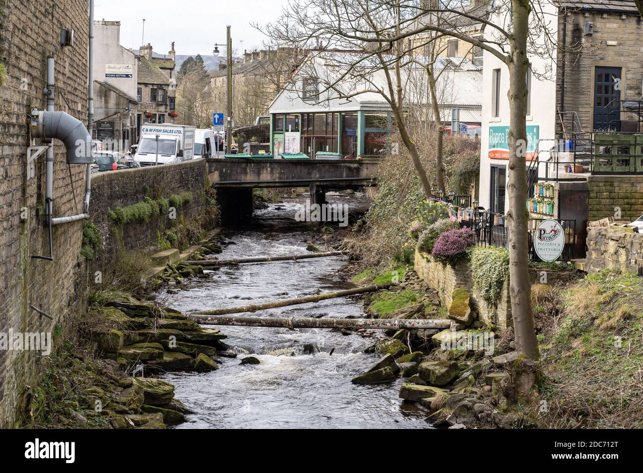 the river holme at holmfirth showing the market hall and exposed drain pipes Stock Photo
