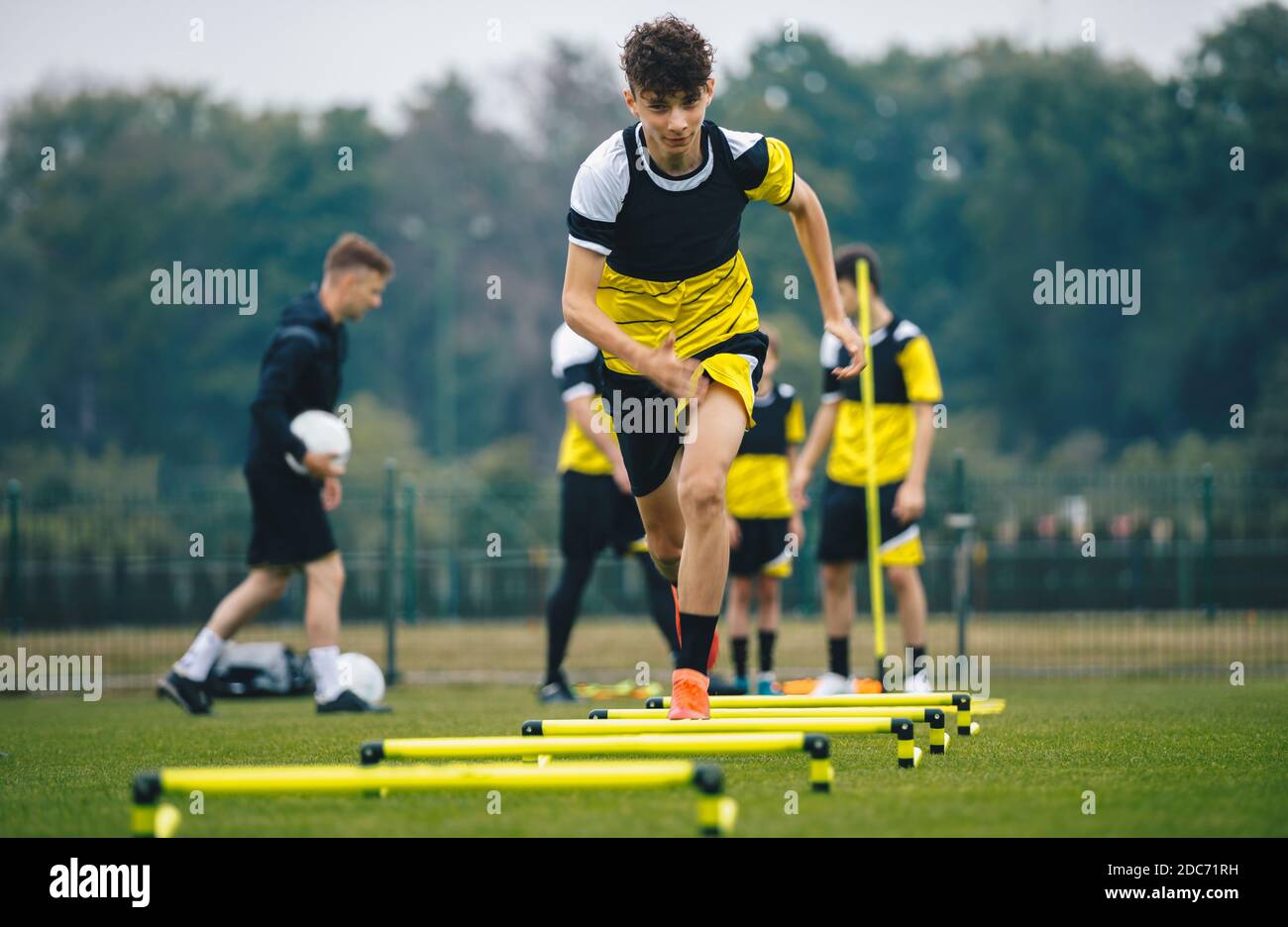 Soccer training on hurdles. Group of young boys in sports football club