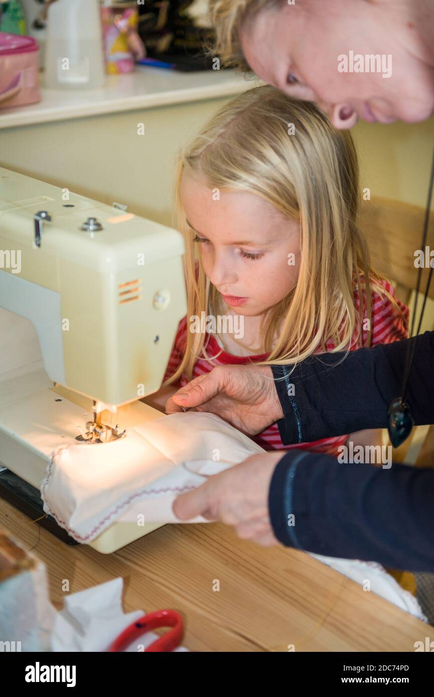 Teaching child girl sewing machine hires stock photography and images
