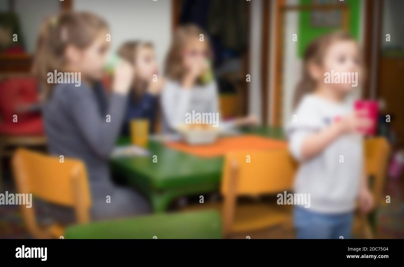 Blurred kids at birthday party, drinking and eating snacks. Image for background usage. Stock Photo