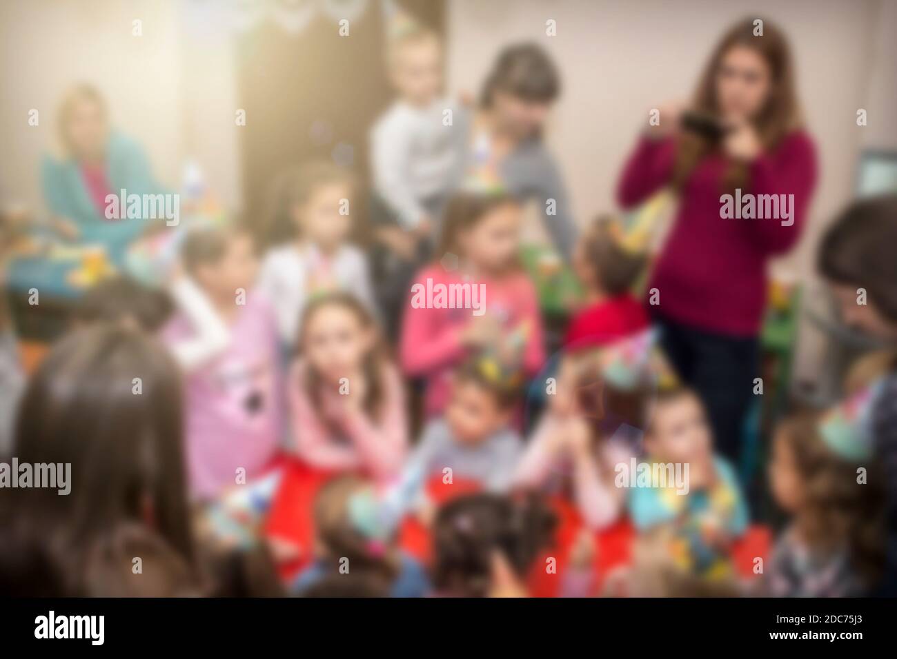 Blurred kids with their moms at birthday party in play room. Image for background use. Stock Photo