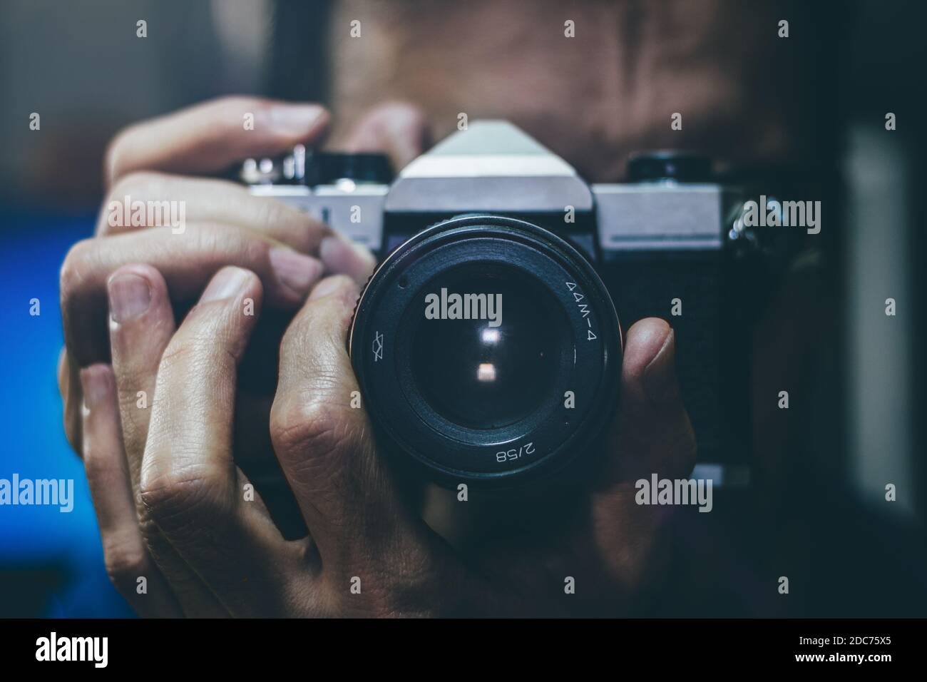 Man taking a photo with an old vintage film camera. Focus on the lens, close up. Stock Photo