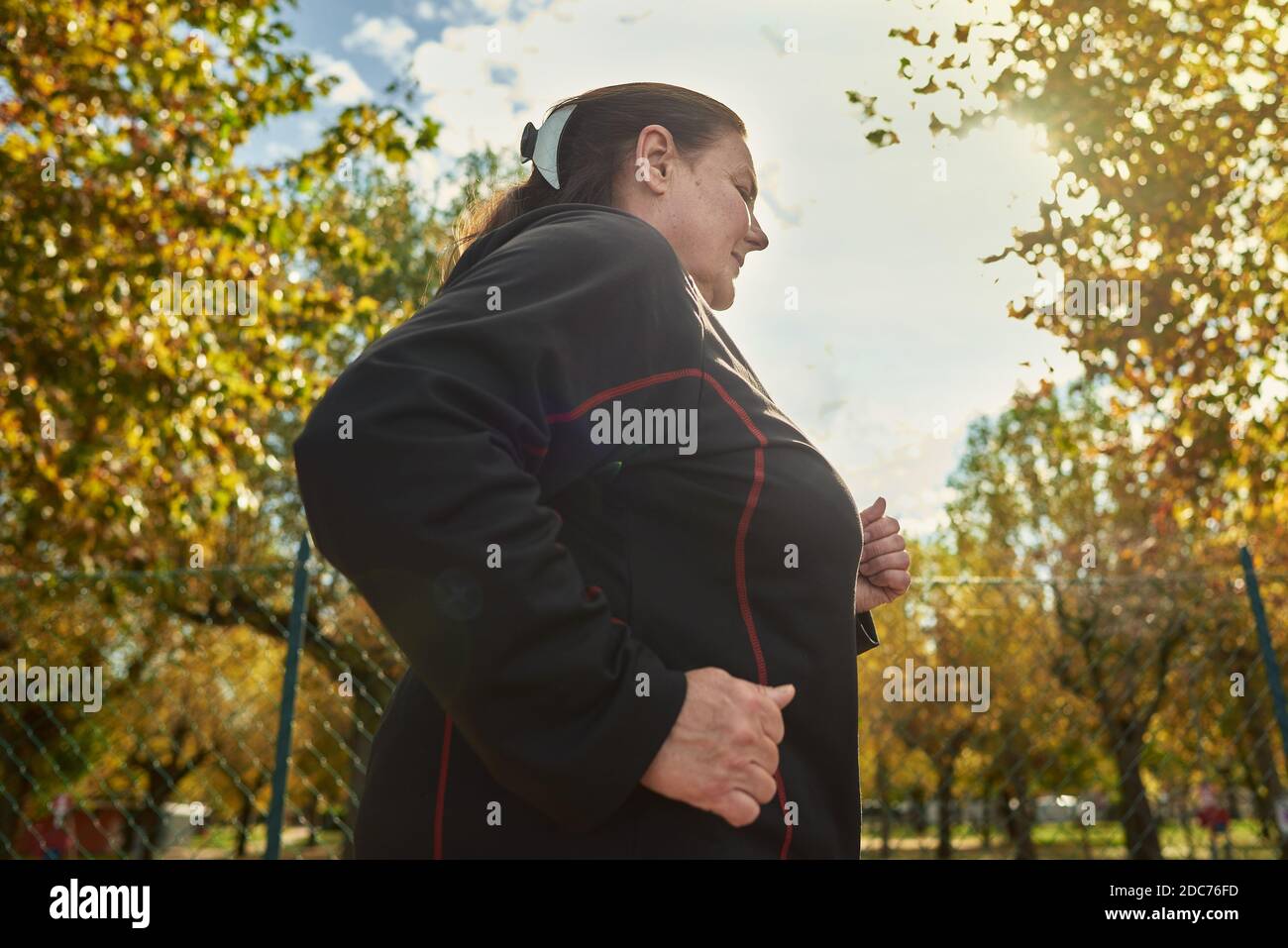 Active senior woman doing healthy exercises outdoors. Jogging Stock Photo