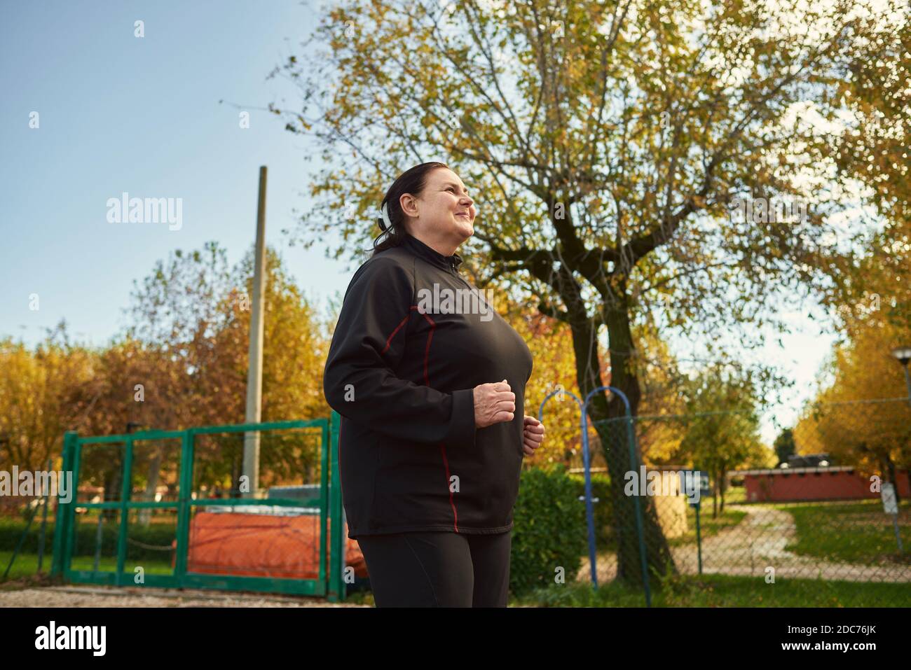 Active senior woman doing healthy exercises outdoors. Jogging Stock Photo