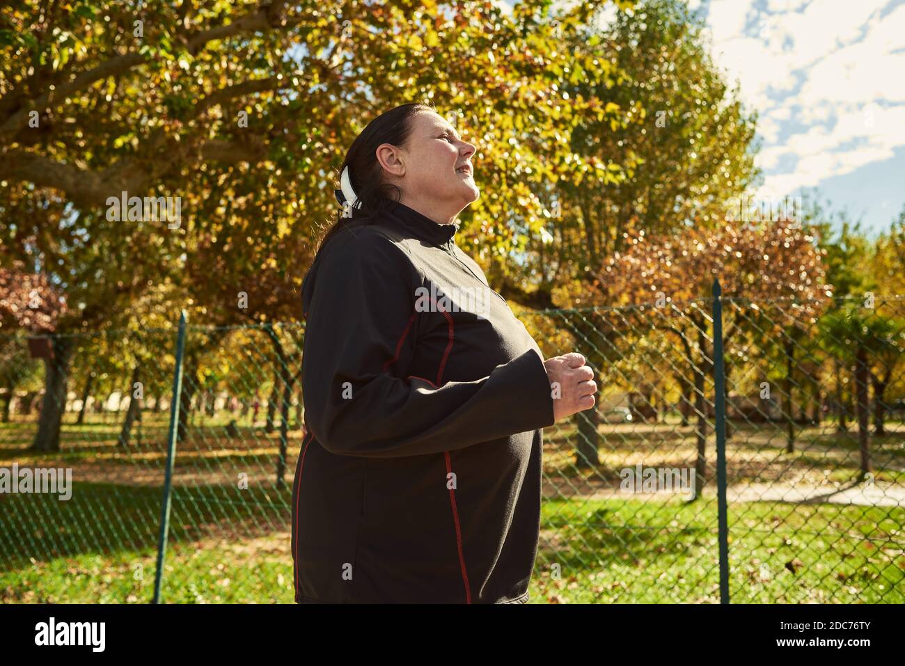 Active senior woman doing healthy exercises outdoors. Jogging Stock Photo