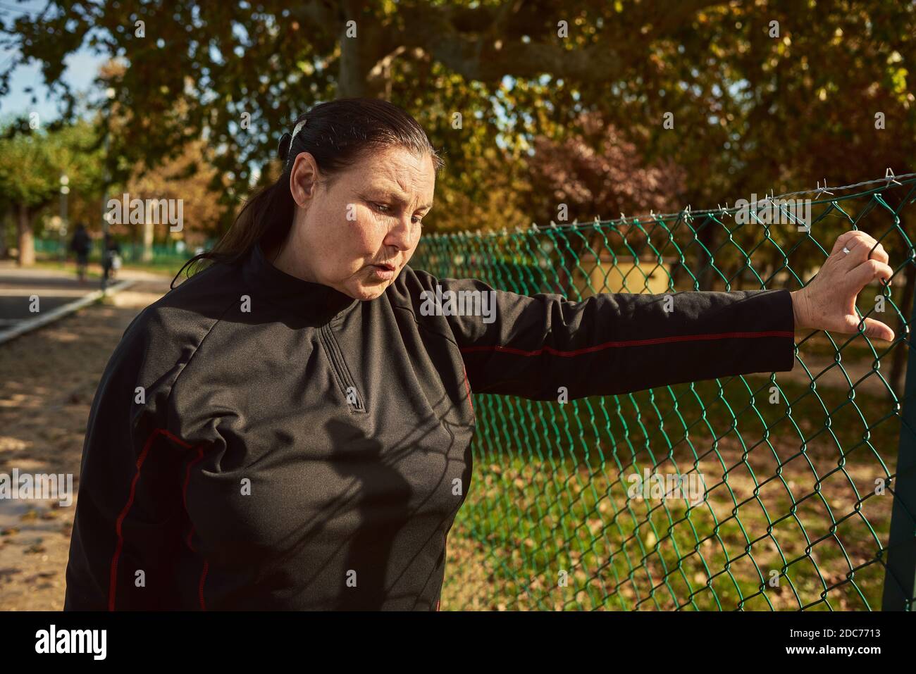 Active senior woman breathing after running outdoors. Stock Photo