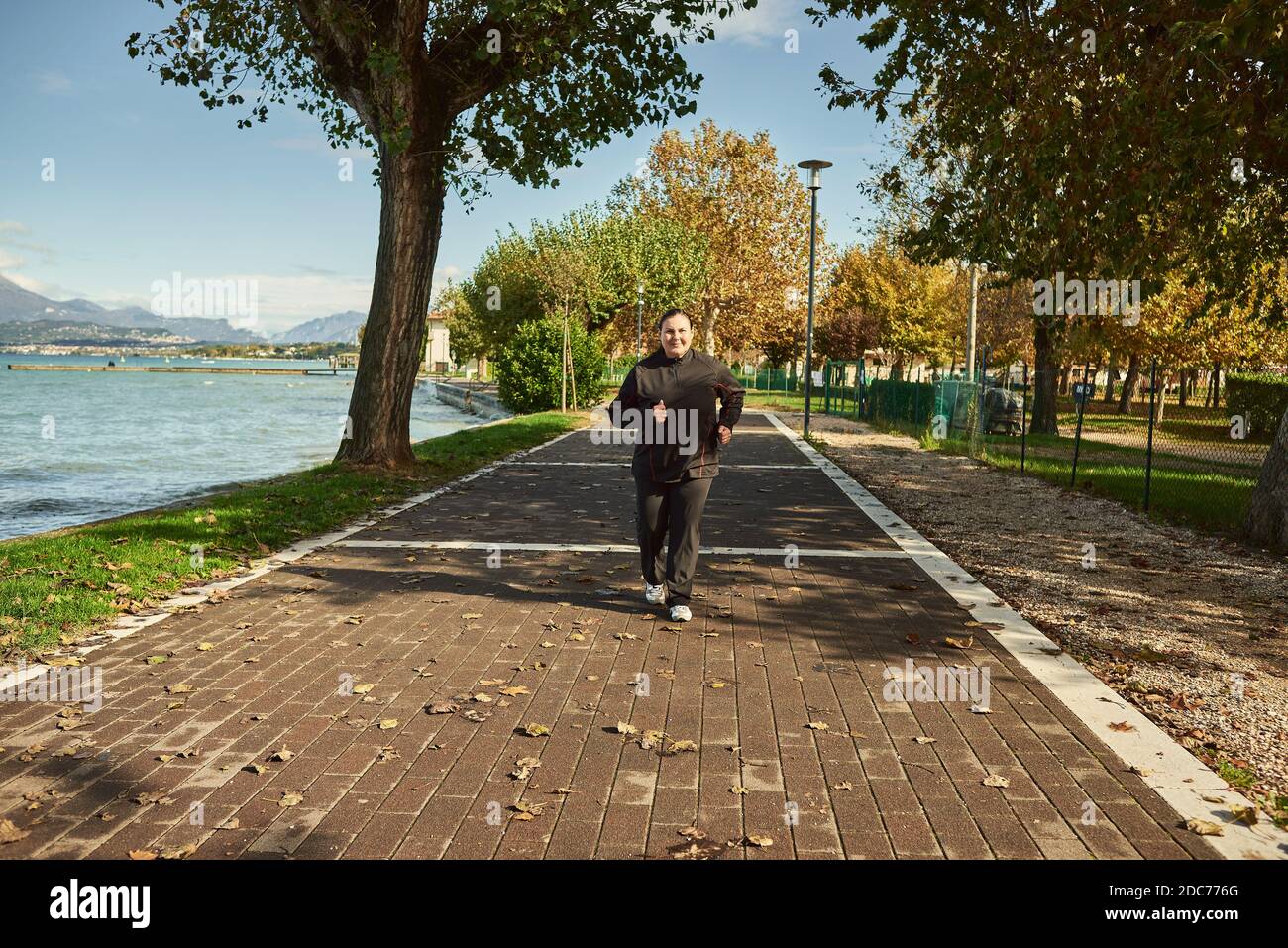 Active senior woman doing healthy exercises outdoors. Jogging Stock Photo