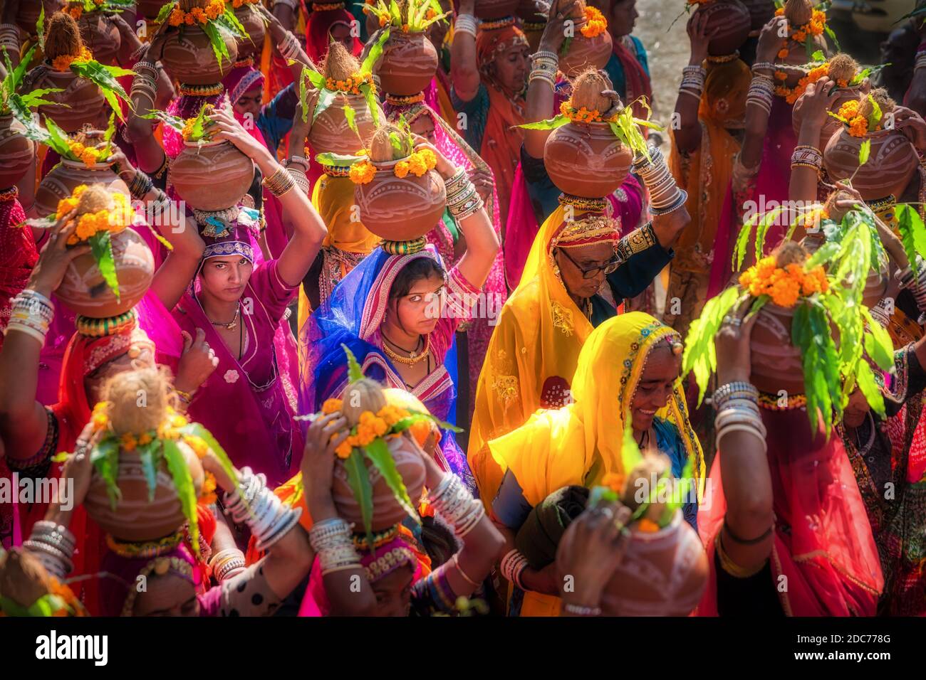 Indian women carrying offerings on their heads during a Rajasthan festival, Pushkar, India Stock Photo