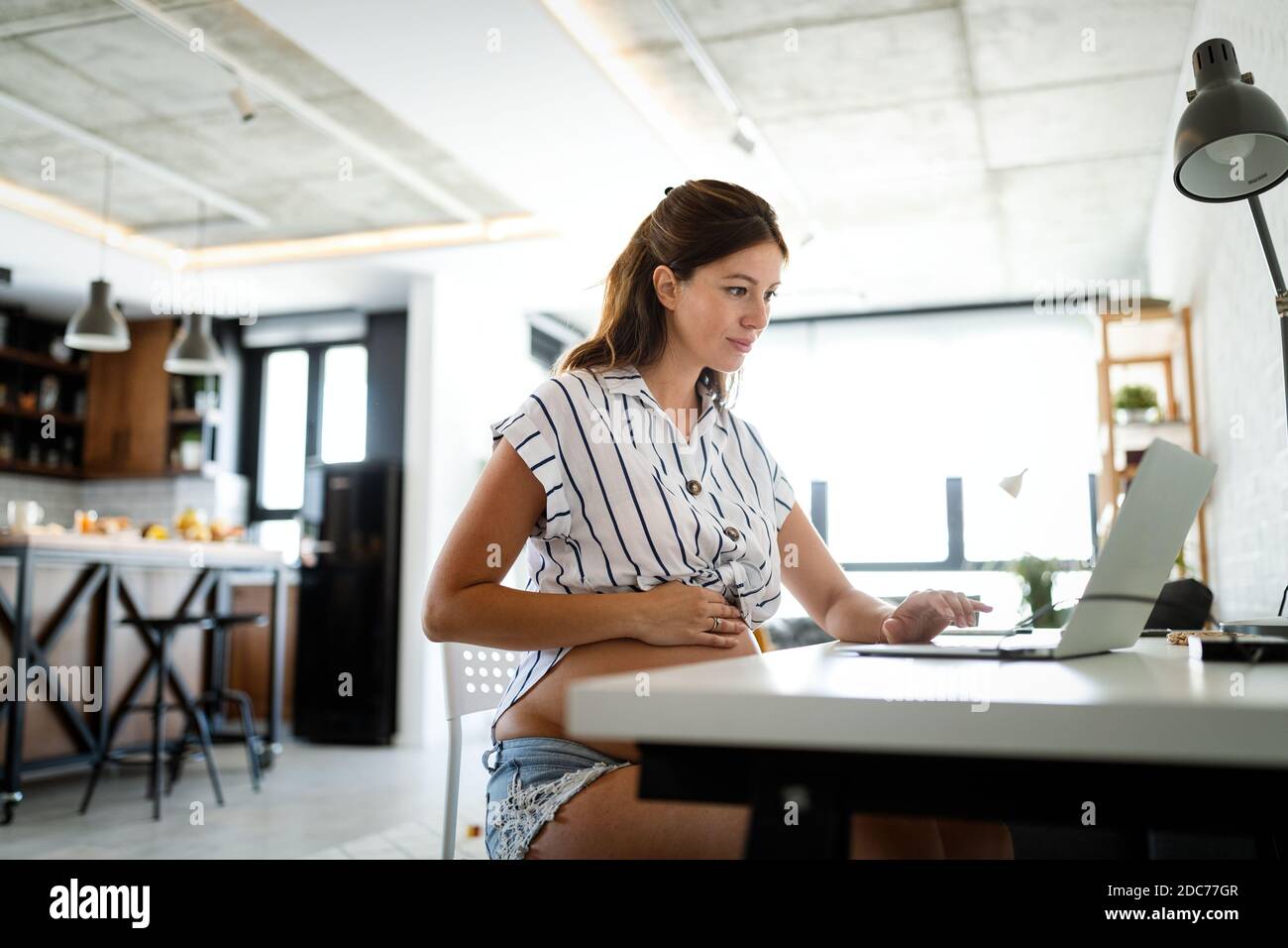 Pregnant woman working from home. Career and pregnancy concept Stock