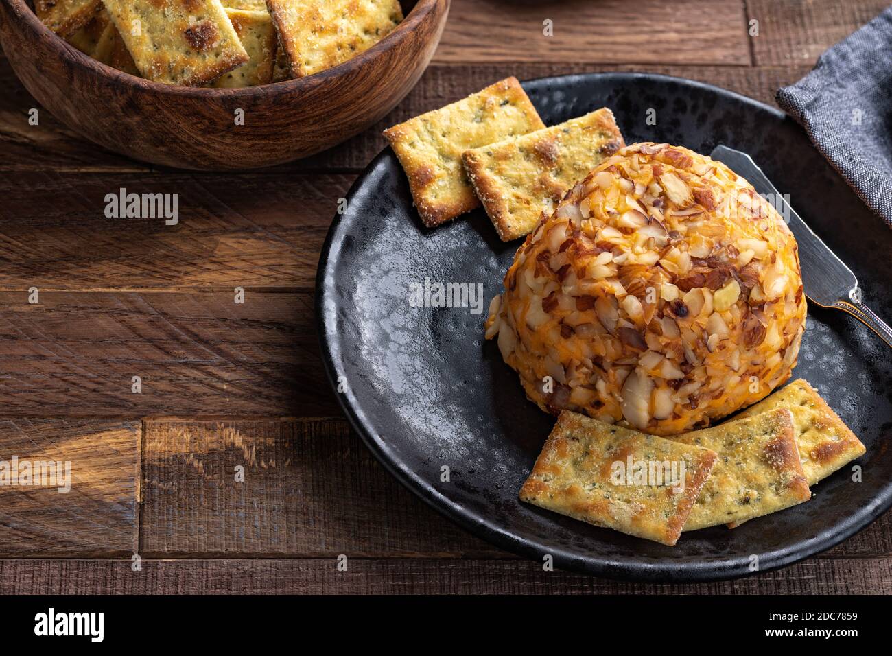 Cheddar cheese ball and crackers on a black plate.  High angle view with copy space Stock Photo