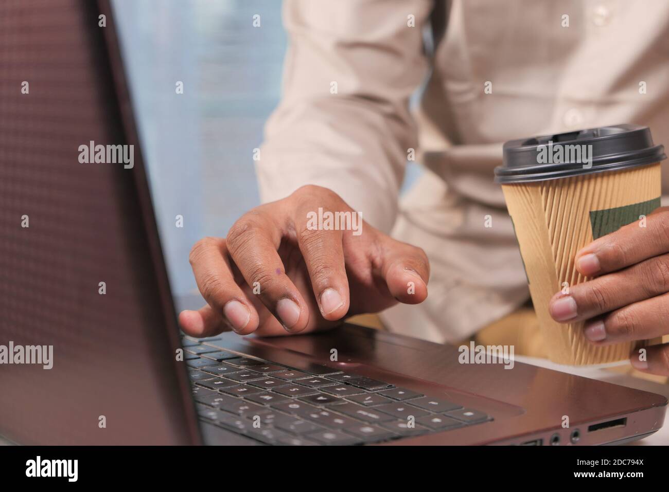 young man using laptop and drinking coffee Stock Photo