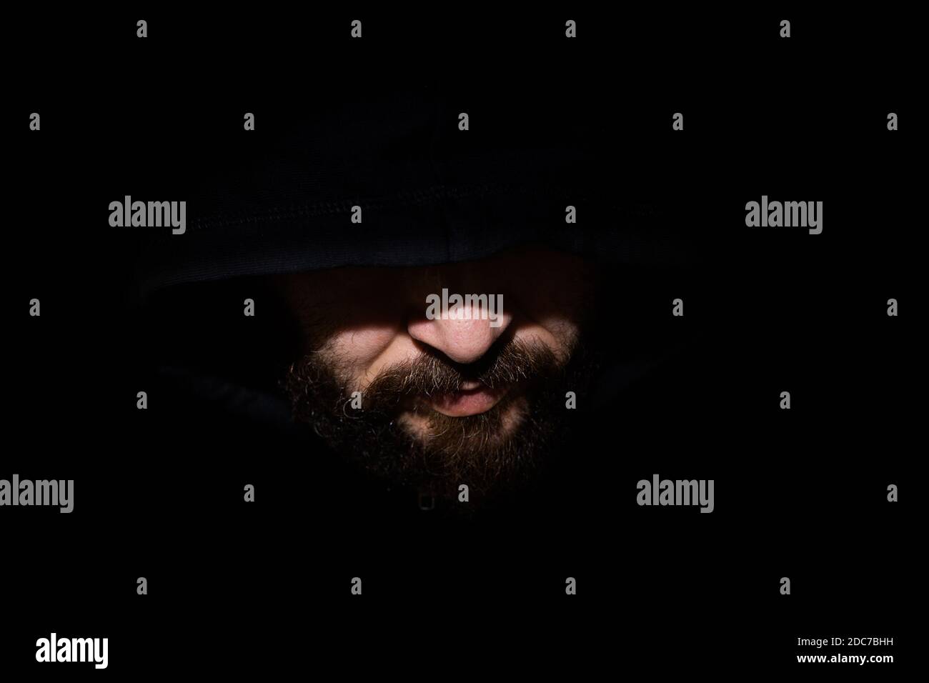 Man with a hood in the dark Stock Photo - Alamy
