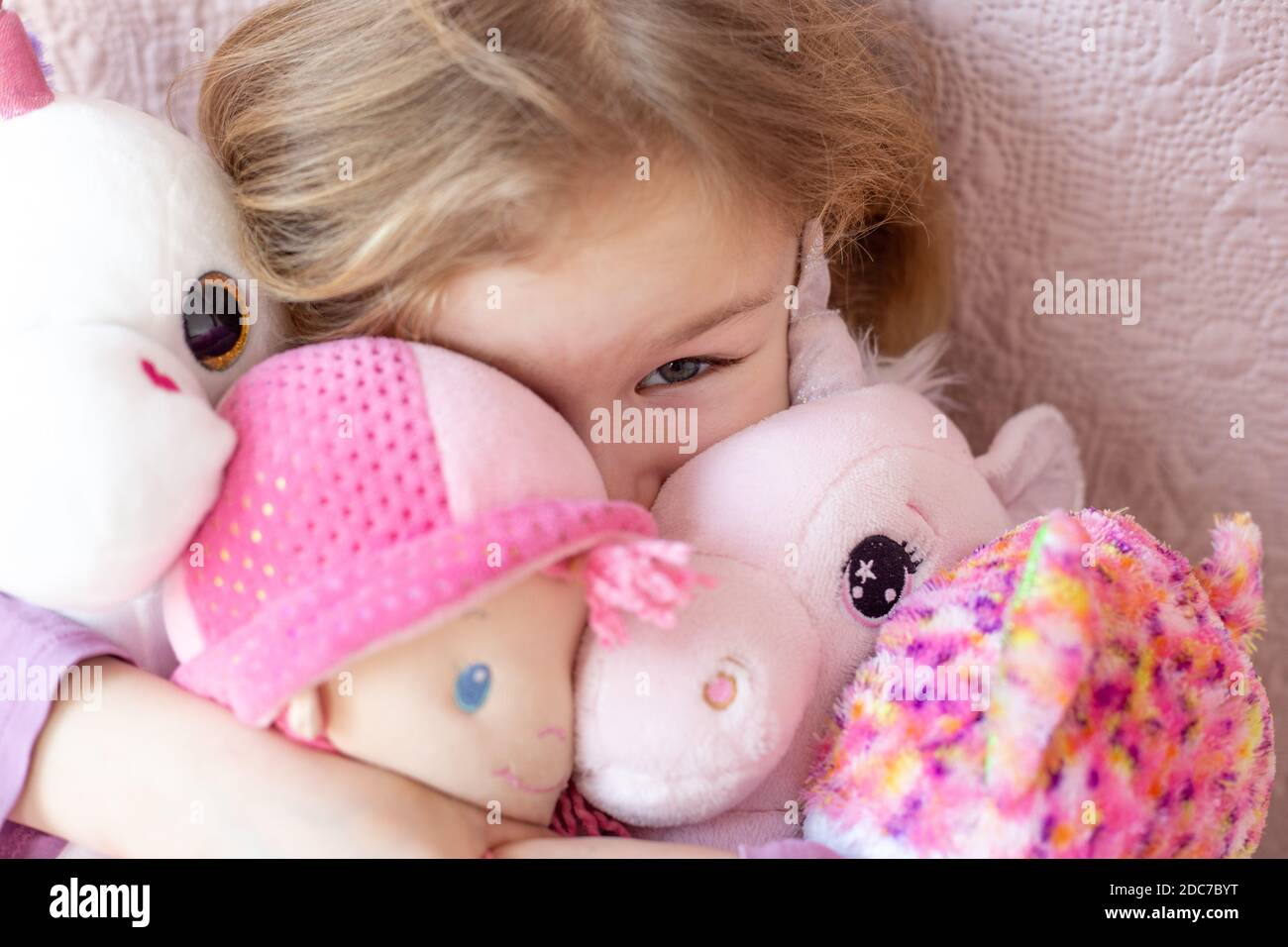 Happy little blonde girl playing with her toys Stock Photo