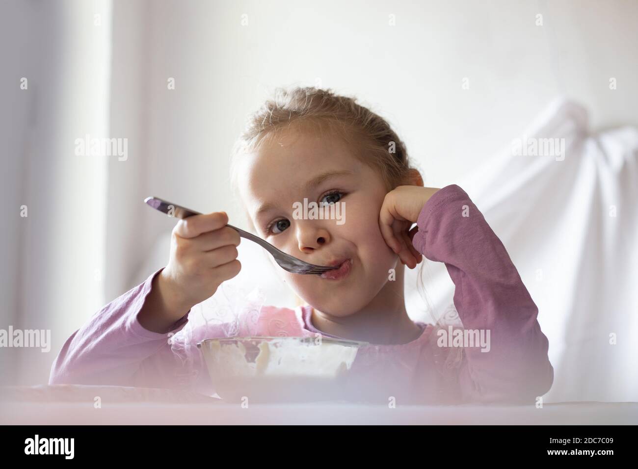 Little blonde girl having lunch Stock Photo