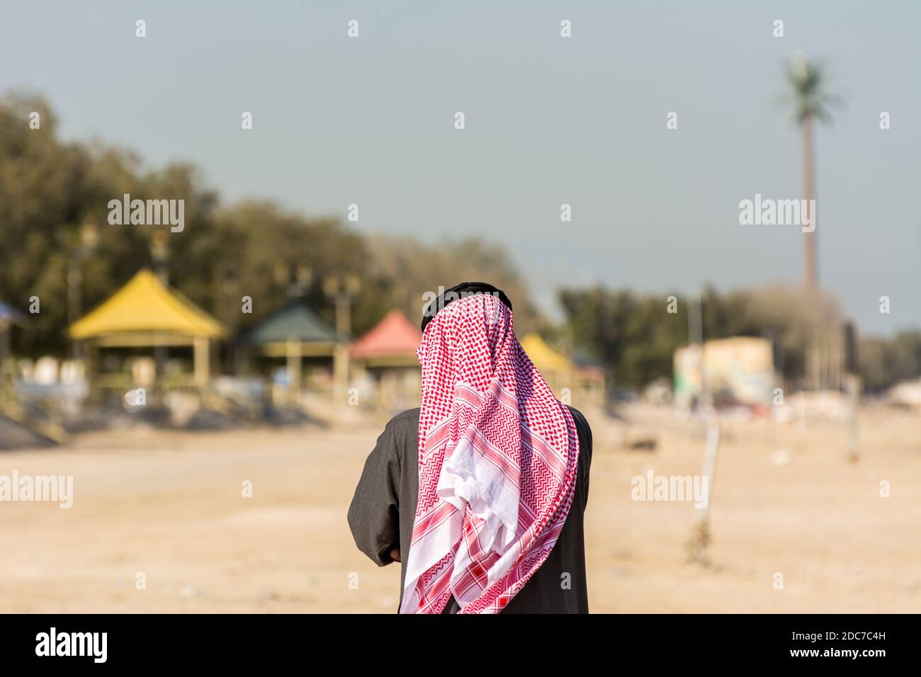 A Saudi Arabian man wearing traditional arabian clothes with background of the corniche park in Dammam, Kingdom of Saudi Arabia Stock Photo