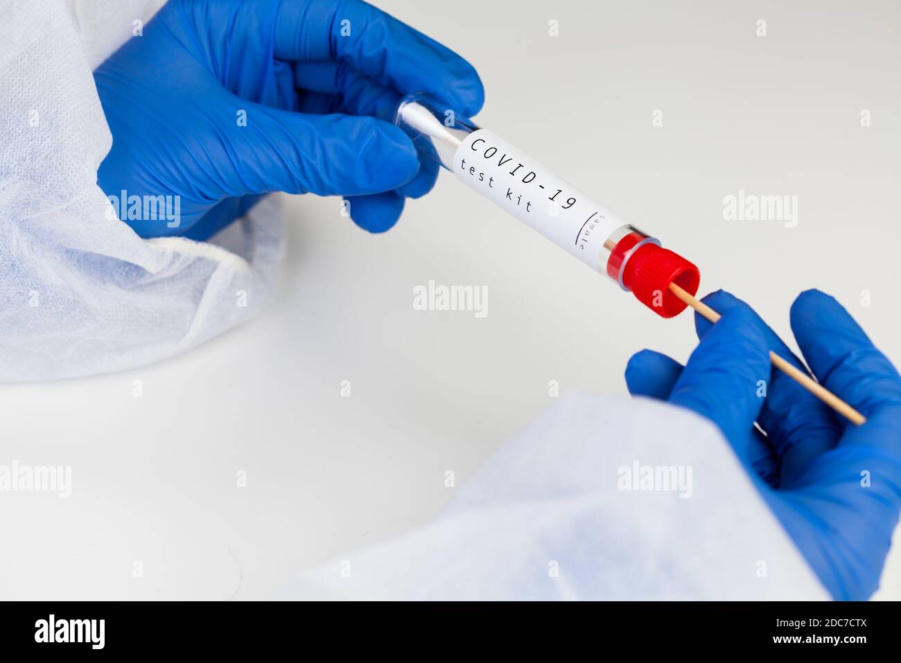 Coronavirus COVID-19 testing kit,swab collection equipment,sterile vacutainer with swabbing stick,closeup of hands in blue protective gloves holding t Stock Photo