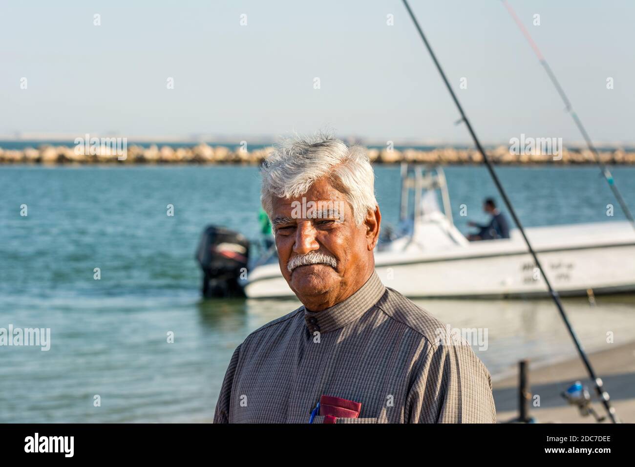 A midaged Saudi Arabian man fishing at the beach of corniche park