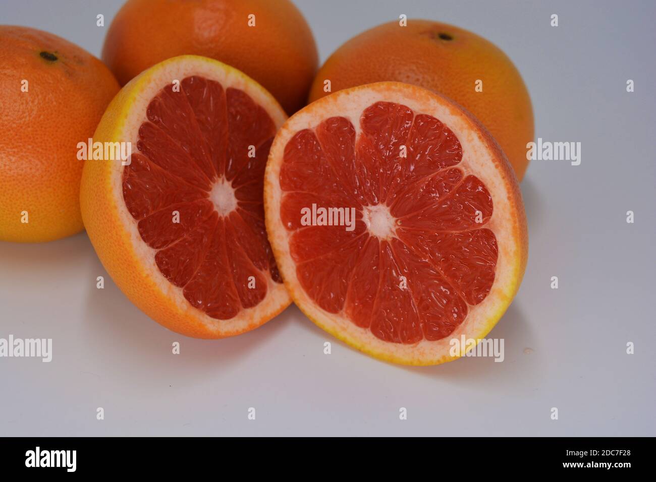Large ripe orangeyellow grapefruits with a juicy grapefruit cut into