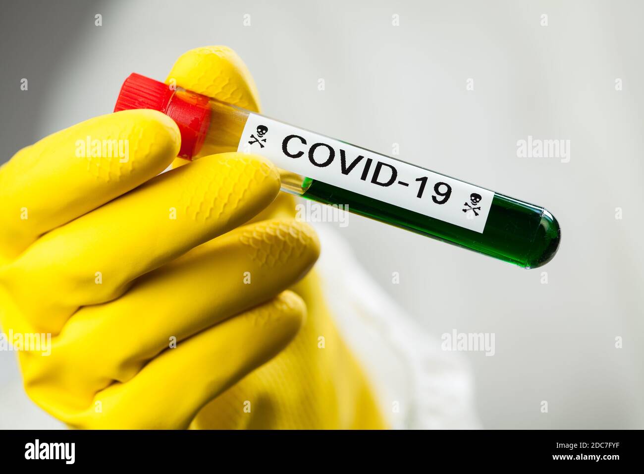 Lab scientist or medical technologist holding test tube with Coronavirus COVID-19 toxic green liquid, science fiction illustration of deadly corona Stock Photo