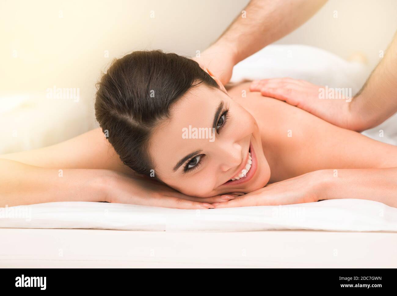 Smiling mixed race woman during a classic therapeutic back massage at a wellness spa Stock Photo