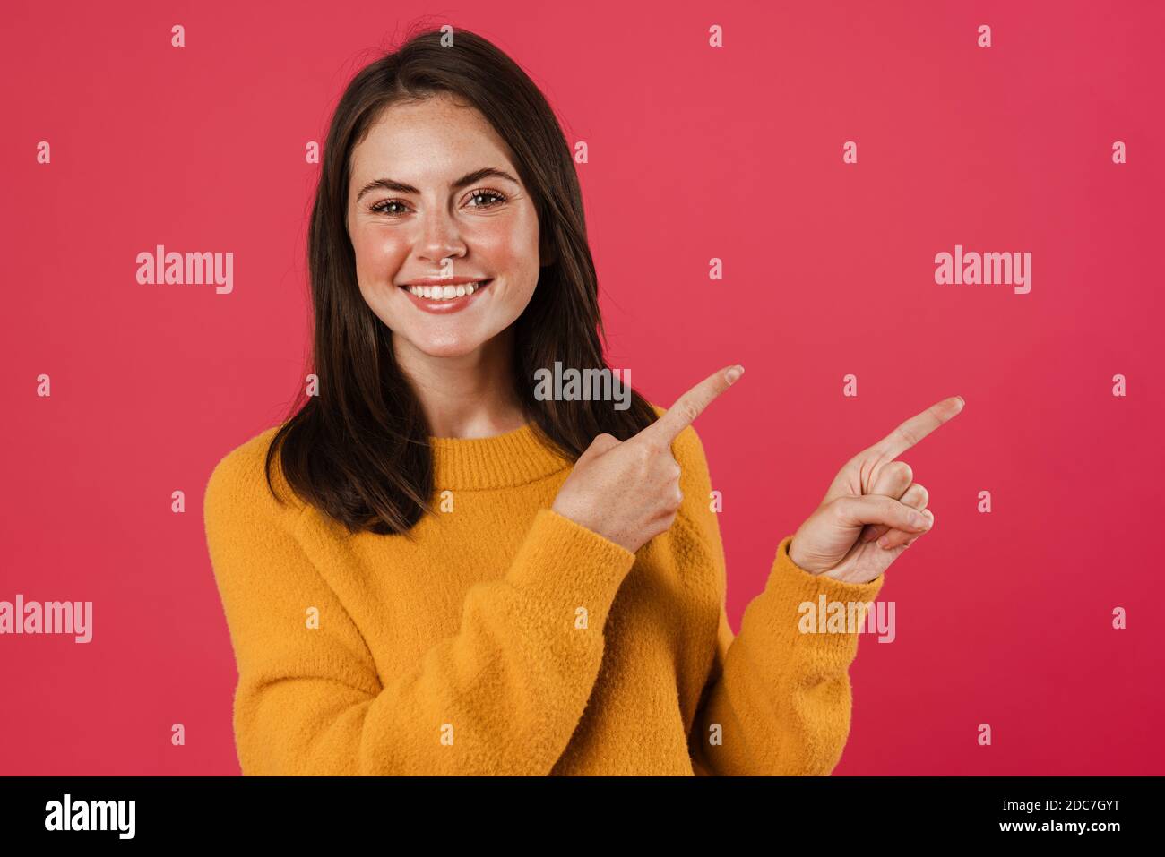 Image of joyful beautiful girl pointing fingers aside isolated over ...