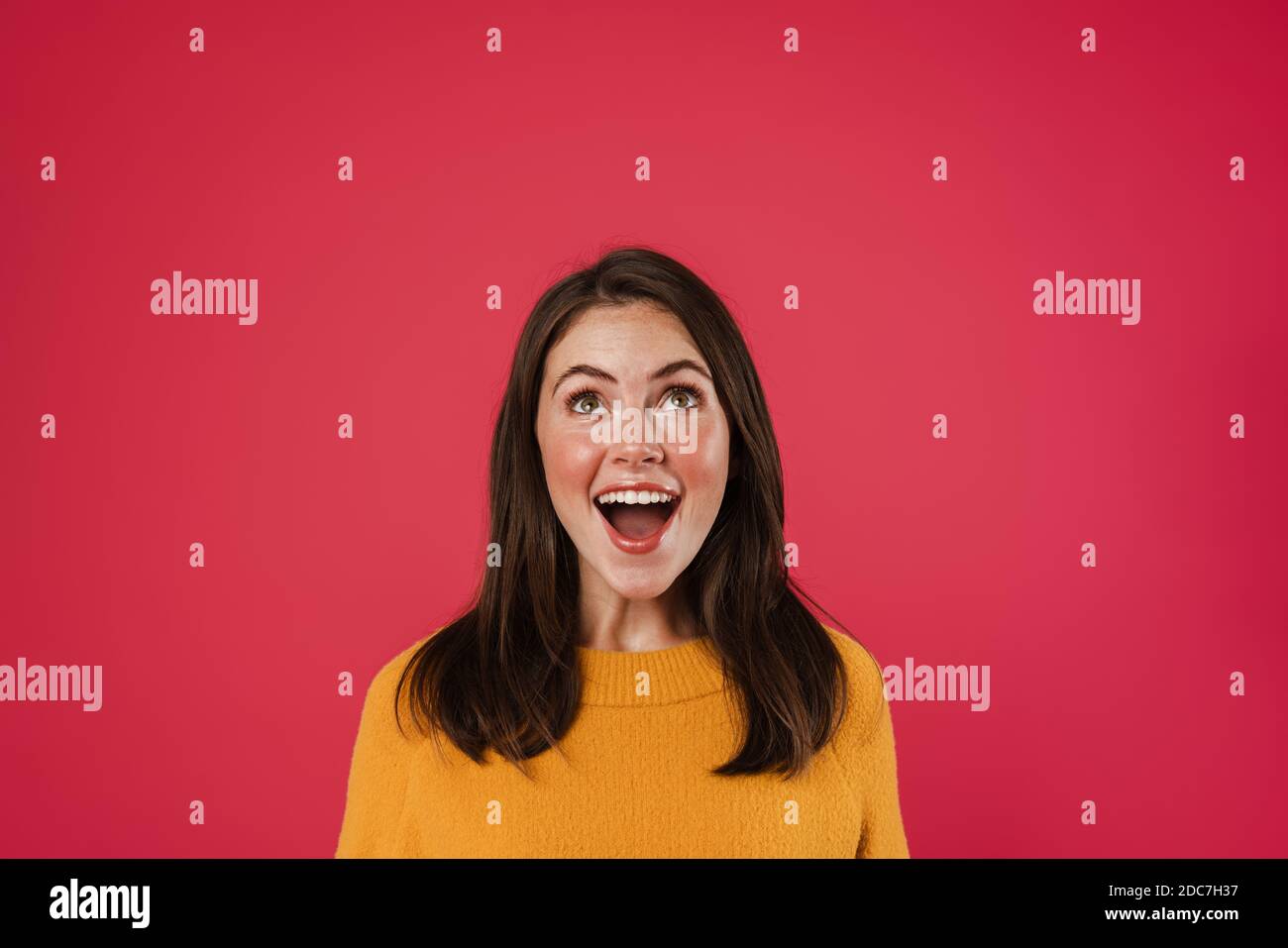 Image of excited beautiful girl posing and looking upward isolated over ...