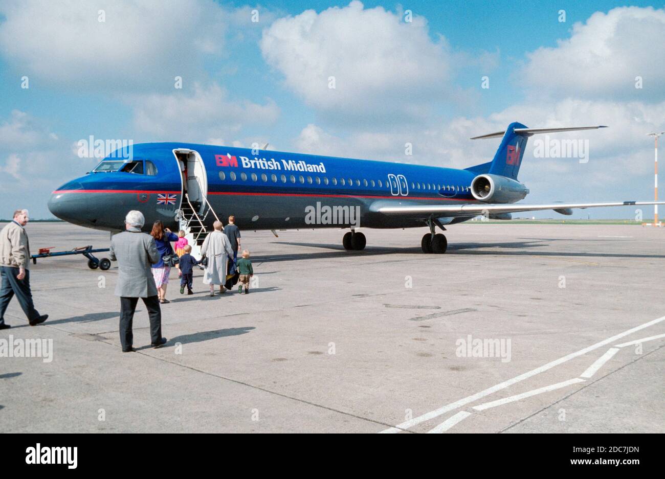 A British Midland Airways Douglas DC-9 on the tarmac at an airport in England during the 1990s. Then front steps are down and passengers are  boarding the aircraft. Stock Photo