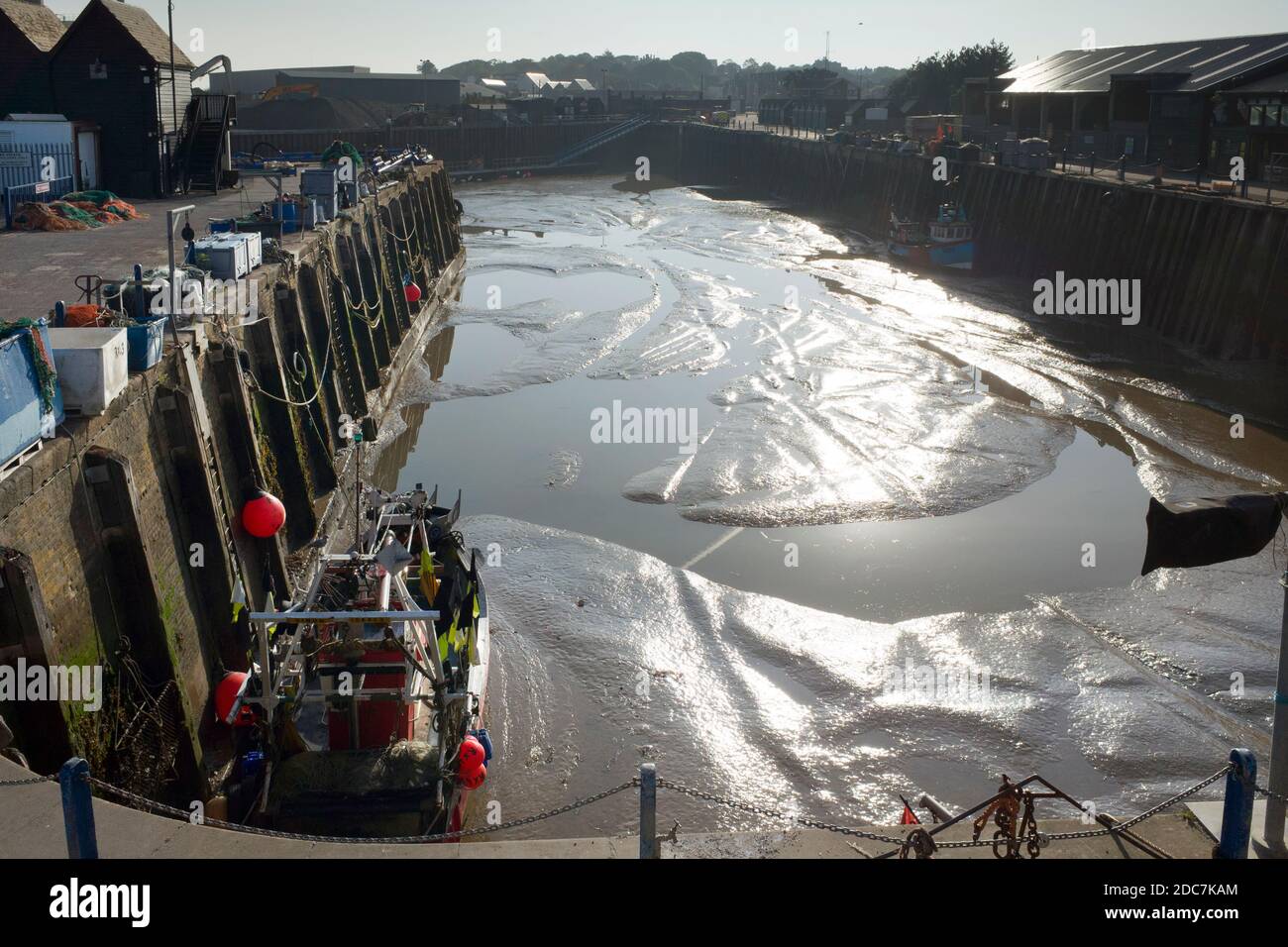 British fishing boat stuck in dry silted Whitstable harbour, Kent United Kingdom England. Stock Photo