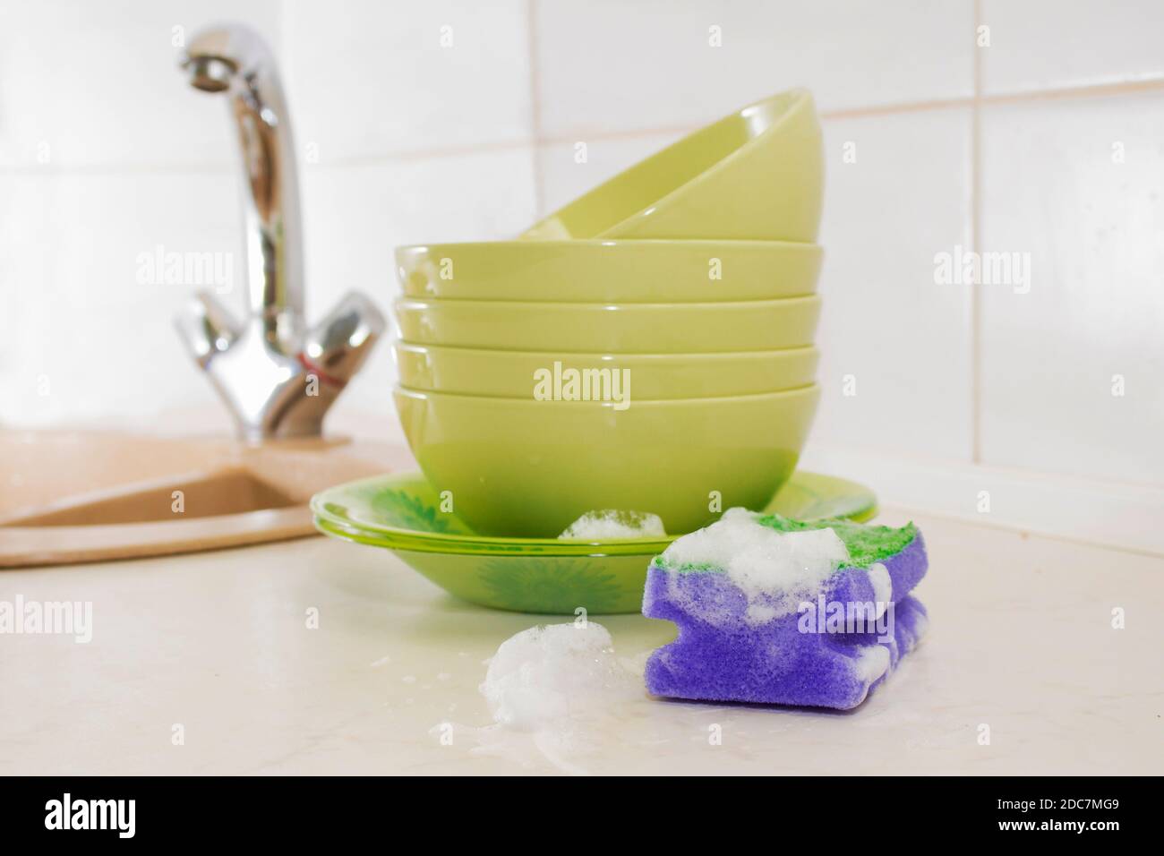 Several colorful plates, kitchen sponges. Dishwasher concept Stock